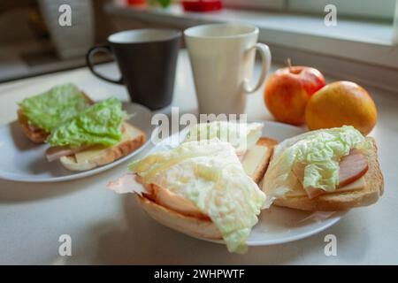 Sandwiches mit Toast, Aufschnitt und Salat zum Frühstück mit zwei Äpfeln Stockfoto