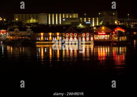 Beleuchtete Gebäude am Wasser bei Nacht in Svolvaer, Norwegen, Skandinavien, Europa im Oktober Stockfoto