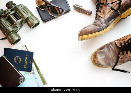 Wanderschuhe, Fernglas, Reisepass und andere Accessoires für Wanderurlaub, flach auf hellem Hintergrund, Kopierraum Stockfoto