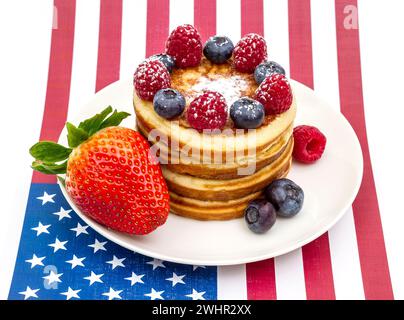 Haufen Pfannkuchen mit Beeren auf der US-Flagge Stockfoto