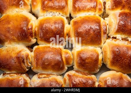 Traditionelle, hausgemachte Hefebrötchen, gefüllt mit Marmelade. Nahaufnahme mit braunem, leckerem, hausgemachtem Gebäck Stockfoto