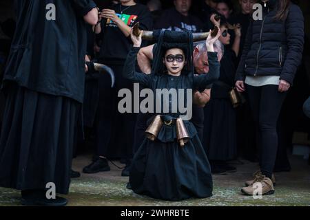 Luzon, Spanien. Februar 2024. Ein Mädchen ist bereit, den Teufel mit Stierhörnern bei einem traditionellen Karneval in Luzon, Spanien, am Samstag, den 10. Februar 2024 zu vertreten. Luzons Karneval, der vermutlich bis in die keltische Zeit zurückreicht, zeigt Teufel und Menschen, die mit bunten Röcken und weißen Gesichtsmasken gekleidet sind. Foto: Paul Hanna/UPI. Quelle: UPI/Alamy Live News Stockfoto