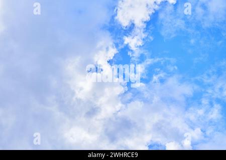 Eine ruhige Szene mit flauschigen Wolken, die in einem leuchtend blauen Himmel verstreut sind und die Ruhe der Natur reflektieren. Stockfoto