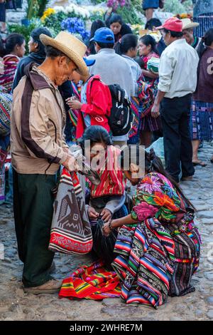 Chichicastenango, Guatemala.  Quiche (Kiche, k ' iche ') Mann und zwei Frauen in Sonntagsmarkt. Stockfoto