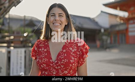 Die wunderschöne hispanische Frau posiert strahlend, lacht und lächelt und strahlt Selbstvertrauen aus im yasaka-Tempel in kyoto, japan. Stockfoto