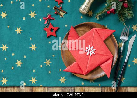 Tisch für Weihnachtsessen, Weihnachtskomposition. Tischgabel und Messer Set mit roter Papierserviette und Tannenzweig auf Rost Stockfoto