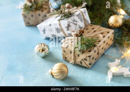 Weihnachtskugeln, Wintertanne mit Geschenkboxen und weihnachtsdekor auf blauem Steinhintergrund. Weihnachten und Neujahr Stockfoto