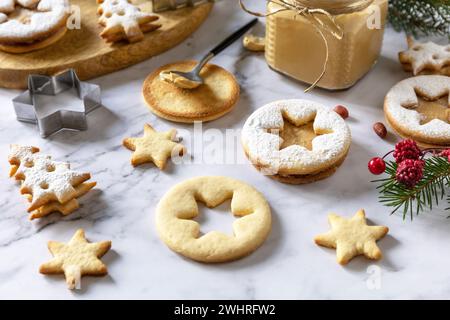 Traditionelle österreichische Weihnachtsplätzchen. Linzer Weihnachts- oder Neujahrskekse gefüllt mit Erdnussbutter auf einer Marmorplatte. Stockfoto