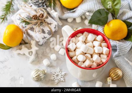 Weihnachten Winter gemütliche Tasse mit heißem Schokoladengetränk mit Marshmallow und Geschenken, Mandarinen auf einem grauen Steinhintergrund. Weihnachten Stockfoto