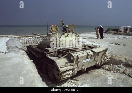 Erster Golfkrieg: 10. März 1991 ein verlassener sowjetischer Panzer Typ 69 in seinem sandsackigen Gewand am Anjafa Beach in Kuwait City. Stockfoto