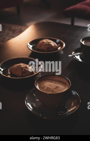 Kaffeetassen mit Keksen. Frühstück für zwei Personen. Innenausstattung des Cafés. Kaffee-Stillleben. Espresso mit cremigem Schaum und Dessert. Süßes Dessert. Stockfoto