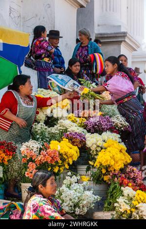 Chichicastenango, Guatemala. Quiche (Kiche, K'iche') Frauen Kaufen und Verkaufen Blumen außerhalb der Kirche von Santo Thomas, Sonntag Morgen. Stockfoto