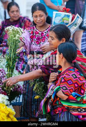 Chichicastenango, Guatemala. Quiche (Kiche, K'iche') Frauen Kaufen und Verkaufen Blumen außerhalb der Kirche von Santo Thomas, Sonntag Morgen. Stockfoto