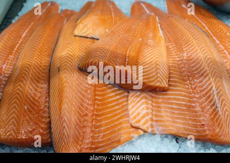 Frisches rohes Lachsfilet in Eis zum Verkauf auf einem Freiluftmarkt. Nahaufnahme von orangefarbenen Fisch, gesunden Meeresfrüchten, Omega 3, Sushi, Sashimi. Stockfoto