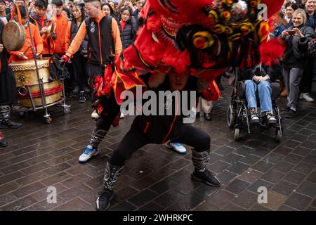 Menschenmassen versammeln sich um einen Drachentänzer in China Town, London. Tausende feiern das chinesische Neujahr, das Jahr des Drachen. Stockfoto