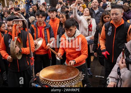 Menschenmassen versammeln sich um einen Drachentänzer in China Town, London. Tausende feiern das chinesische Neujahr, das Jahr des Drachen. Stockfoto