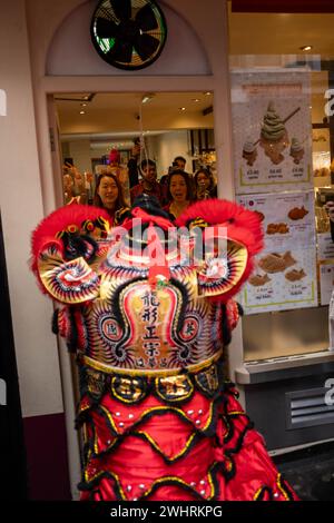 Menschenmassen versammeln sich um einen Drachentänzer in China Town, London. Tausende feiern das chinesische Neujahr, das Jahr des Drachen. Stockfoto