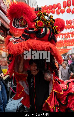 Menschenmassen versammeln sich um einen Drachentänzer in China Town, London. Tausende feiern das chinesische Neujahr, das Jahr des Drachen. Stockfoto