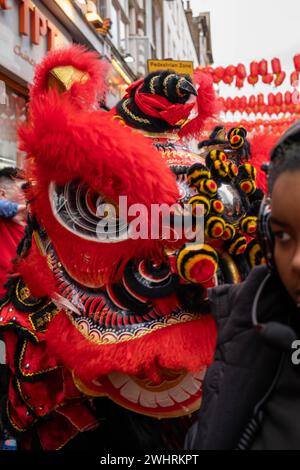 Menschenmassen versammeln sich um einen Drachentänzer in China Town, London. Tausende feiern das chinesische Neujahr, das Jahr des Drachen. Stockfoto