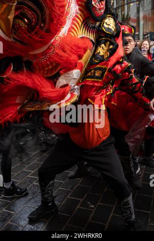 Menschenmassen versammeln sich um einen Drachentänzer in China Town, London. Tausende feiern das chinesische Neujahr, das Jahr des Drachen. Stockfoto