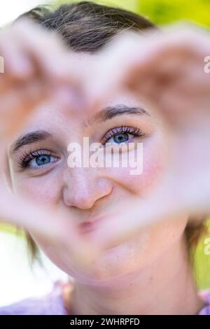 Herzlicher Blick: Frau umrahmt von liebevollen Händen Stockfoto