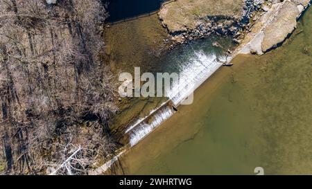 Luftaufnahme nach unten auf einen von Menschen geschaffenen Wasserfall für eine Mühle, an einem sonnigen Tag Stockfoto