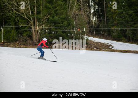 Ein Skifahrer fährt auf einem steilen Hügel Ski. Stockfoto