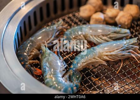Gegrillte Flussgarnelen auf einem heißen Holzkohlegrill. Gegrillte Garnelen, thailändische Grillgerichte. Stockfoto