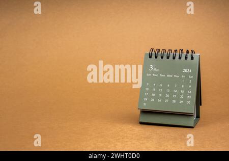 Grün vom März 2024 Schreibtischkalender für den Organisator zur Planung und Erinnerung isoliert auf braunem Bastelpapier Hintergrund mit Kopierraum, minimalem Stil. Klein Stockfoto