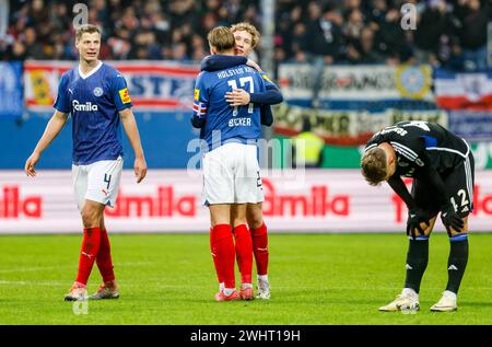 11. Februar 2024, Schleswig-Holstein, Kiel: Fußball, 2. Bundesliga, Holstein Kiel - FC Schalke 04, 21. Spieltag, Holsteinstadion. Kiels Patrick Erras (l-r), Kiels Timo Becker, Kiels lasse Rosenboom und Schalkes Thomas Ouwejan reagieren nach dem letzten Pfeifen. Das Match endete 1:0. Foto: Axel Heimken/dpa - WICHTIGER HINWEIS: Gemäß den Vorschriften der DFL Deutschen Fußball-Liga und des DFB Deutschen Fußball-Bundes ist es verboten, im Stadion und/oder des Spiels aufgenommene Fotografien in Form von sequenziellen Bildern und/oder videoähnlichen Fotoserien zu verwenden oder zu nutzen. Stockfoto