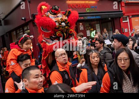 Menschenmassen versammeln sich um einen Drachentänzer in China Town, London. Tausende feiern das chinesische Neujahr, das Jahr des Drachen. Stockfoto