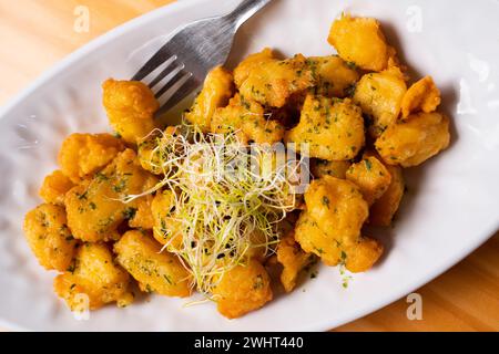Gebratener Tintenfisch mit Knoblauch und Petersilie. Traditionelle frittierte Fisch-Tapa in Spanien. Stockfoto