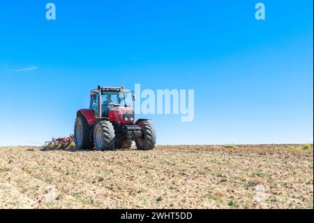 Landwirtschaftliche Maschinen im Vordergrund Arbeiten im Feld Stockfoto