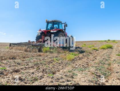 Landwirtschaftliche Maschinen im Vordergrund Arbeiten im Feld Stockfoto