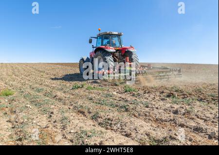 Landwirtschaftliche Maschinen im Vordergrund Arbeiten im Feld Stockfoto