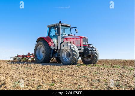 Landwirtschaftliche Maschinen im Vordergrund Arbeiten im Feld Stockfoto