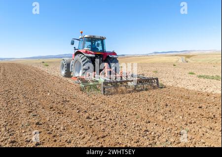 Landwirtschaftliche Maschinen im Vordergrund Arbeiten im Feld Stockfoto