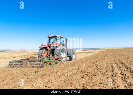 Landwirtschaftliche Maschinen im Vordergrund Arbeiten im Feld Stockfoto