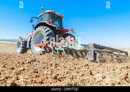 Landwirtschaftliche Maschinen im Vordergrund Arbeiten im Feld Stockfoto