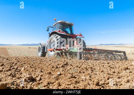 Landwirtschaftliche Maschinen im Vordergrund Arbeiten im Feld Stockfoto