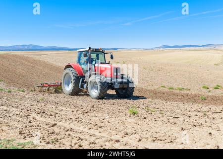 Landwirtschaftliche Maschinen im Vordergrund Arbeiten im Feld Stockfoto
