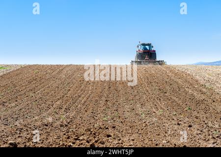 Landwirtschaftliche Maschinen im Vordergrund Arbeiten im Feld Stockfoto