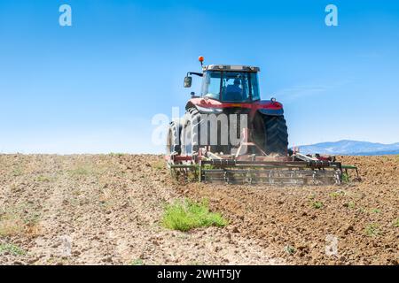 Landwirtschaftliche Maschinen im Vordergrund Arbeiten im Feld Stockfoto