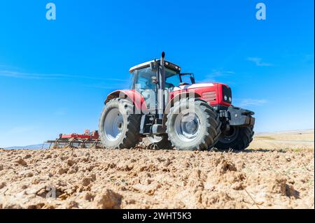 Landwirtschaftliche Maschinen im Vordergrund Arbeiten im Feld Stockfoto