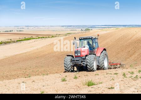 Landwirtschaftliche Maschinen im Vordergrund Arbeiten im Feld Stockfoto