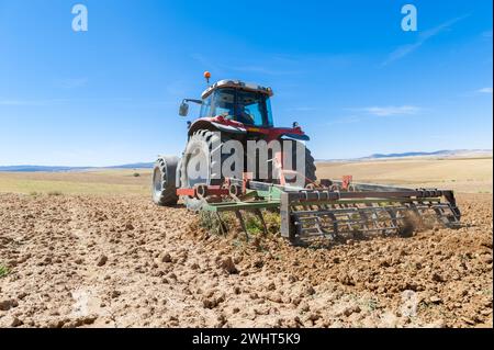 Landwirtschaftliche Maschinen im Vordergrund Arbeiten im Feld Stockfoto