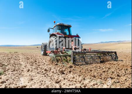 Landwirtschaftliche Maschinen im Vordergrund Arbeiten im Feld Stockfoto