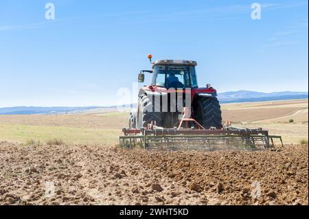 Landwirtschaftliche Maschinen im Vordergrund Arbeiten im Feld Stockfoto