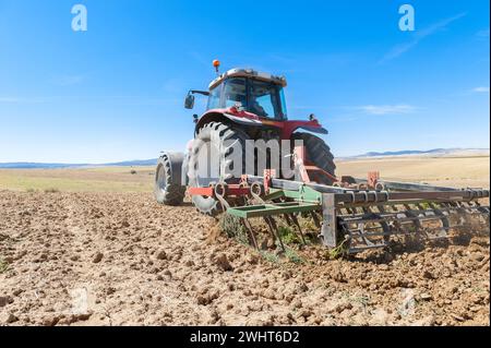Landwirtschaftliche Maschinen im Vordergrund Arbeiten im Feld Stockfoto