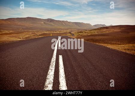 Autobahn durch trockene Kies-Lavafelder unter einem blauen Sommerhimmel Stockfoto